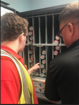 Student refilling a vending machine at a retail establishment.